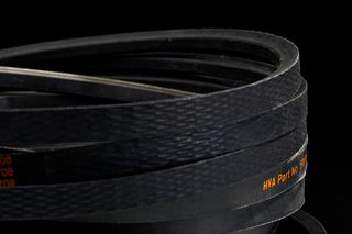 Close-up of multiple black rubber belts stacked together, with visible part numbers.