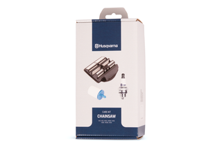 Forfra af et Husqvarna-kit til pleje af kædesave med tændrør og filter.