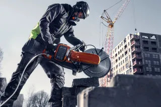 Construction worker using a power cutter on a construction site.