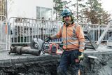Construction worker holding a power cutter at a construction site.