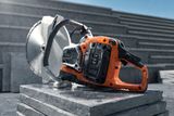 A power cutter resting on stacked concrete slabs at a construction site.