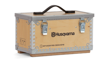 Front view of a Husqvarna branded wooden box with metal reinforcements and a handle.