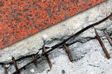 Close-up view of a cracked concrete surface with exposed rusty rebar.
