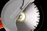 Close-up view of a Husqvarna power cutter blade with rotation direction indicated.