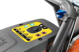 "Husqvarna" gaminio valdymo skydelio vaizdas iš arti su įvairiomis įspėjamosiomis etiketėmis.