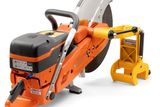 Side view of a Husqvarna power cutter with ergonomic handle and support stand.