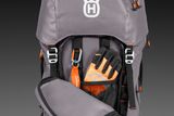 Front view of a Husqvarna backpack with gloves and a first aid kit attached.