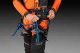 Person adjusting a climbing harness with ropes, wearing work gear.