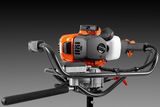 Front view of a construction power tool with ergonomic handles and a fuel tank.