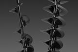 Two large auger drill bits with helical blades, displayed vertically.