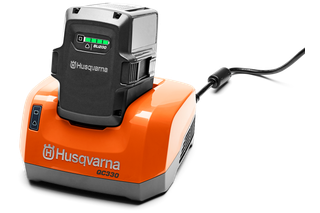 Front view of a Husqvarna battery charger with a battery inserted.