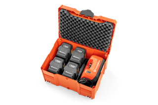 Draufsicht auf einen Husqvarna Akkukoffer mit sechs Akkus und einem Ladegerät.