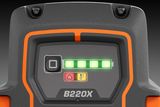 Close-up of a B220X battery indicator showing full charge with warning icons.