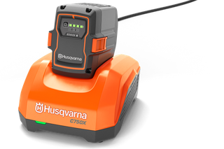 Încărcător Husqvarna 40-C750X. Vedere frontală a unui încărcător de baterie Husqvarna C750X cu baterie atașată.
