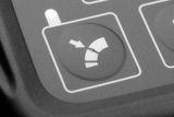 Close-up van een knop op het bedieningspaneel met een pictogram dat de richtingsaanpassing aangeeft.
