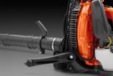 Side view of a leaf blower showing its engine and blower tube.