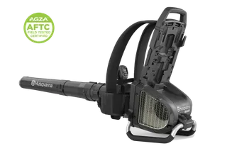 Front angled studio view of a Husqvarna backpack leaf blower with AGZA AFTC certification badge