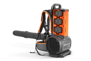 Front-side studio view of a Husqvarna backpack leaf blower with three batteries and harness.