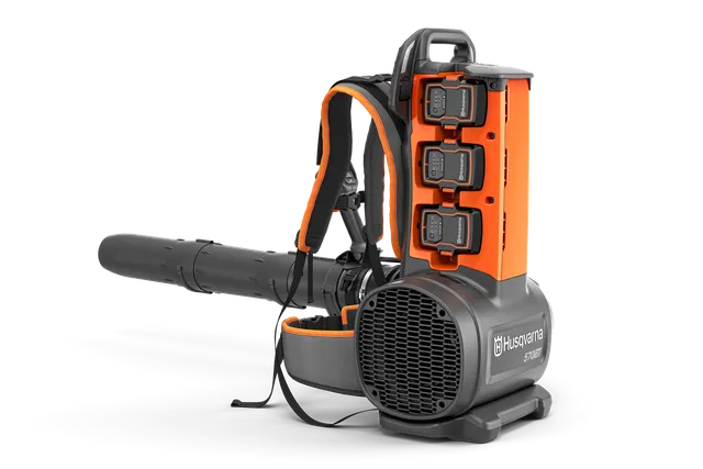 Front-side studio view of a Husqvarna backpack leaf blower with three batteries and harness.