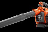 Side view of a Husqvarna leaf blower with ergonomic handle and air intake visible.