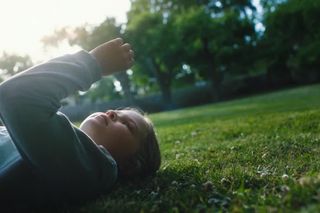 Child relaxing on lawn 6s 16:9 No text