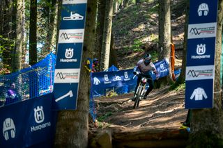 Un ciclista che percorre un sentiero nel bosco durante un evento sponsorizzato da Husqvarna.