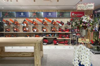 展示棚に複数のチェンソーを並べた屋内ショールームの壁の正面図。