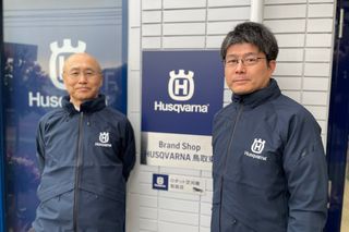 看板が見えるハスクバーナブランドショップの外に立っている2人。