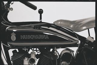 Vista lateral de una motocicleta Husqvarna antigua con motor y asiento visibles.