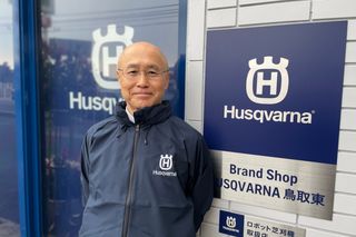ハスクバーナブランドのショップサインの前に立っている人。