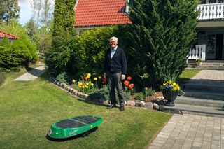 Ingemar Carlsson, winner of the World’s Oldest Husqvarna Robotic Lawn Mower competition, standing with his original Husqvarna Solar Mower