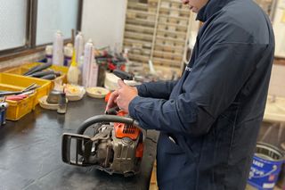 作業場でチェーンソーを扱う人。