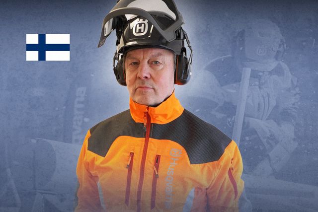 En person som bär Husqvarnas skyddshjälm och skyddskläder med en finsk flagga i bakgrunden.