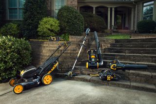 A collection of Poulan Pro outdoor power equipment including a lawn mower, string trimmer, leaf blower, and chainsaw displayed on a driveway.