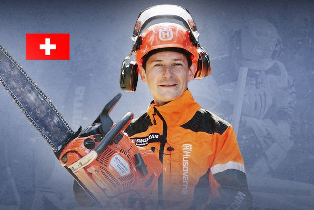 A person holding a Husqvarna chainsaw, wearing a safety helmet and work gear.