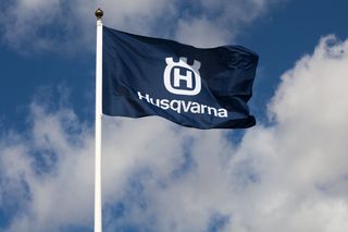 Η σημαία της Husqvarna κυματίζει σε έναν συννεφιασμένο ουρανό.