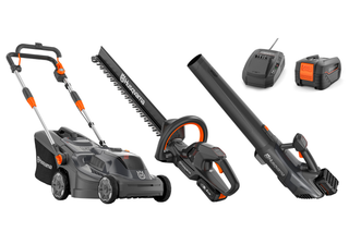 A collection of Husqvarna gardening tools including a lawn mower, hedge trimmer, leaf blower, battery, and charger.