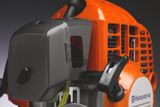 Close-up of a Husqvarna engine component with visible controls and branding.