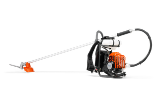 Side view of a Husqvarna backpack brush cutter with a long shaft and cutting blade.
