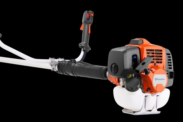 Вигляд збоку кущоріза Husqvarna з ергономічною ручкою та захисним кожухом.
