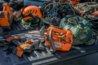 Ланцюгова пилка Husqvarna, розміщена на кузові вантажівки в оточенні робочого спорядження й обладнання.