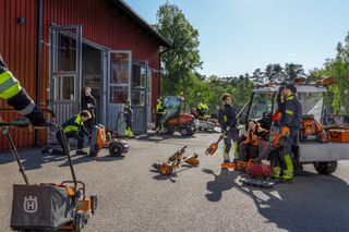 Meerdere werknemers in een buitenruimte met verschillende bouwgereedschappen en -apparatuur.