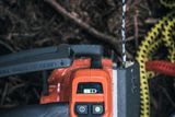 Close-up view of a chainsaw control panel with visible buttons and a display screen.