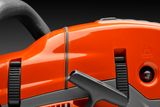 Close-up view of a Husqvarna chainsaw handle and control features.