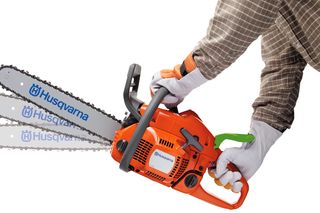 Person holding a Husqvarna chainsaw with three different bar lengths displayed.