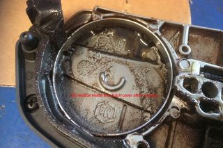 Oil residue inside a clutch cover after cleaning, with visible engravings and markings.