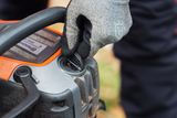 En person som justerar tanklocket på en motorsåg från Husqvarna.