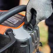 En person som justerar tanklocket på en motorsåg från Husqvarna.