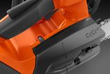 Close-up view of a Husqvarna chainsaw, focusing on the handle and chain area.