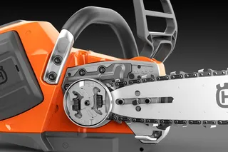 Vue rapprochée d’une tronçonneuse Husqvarna présentant le mécanisme de chaîne et de pignon.